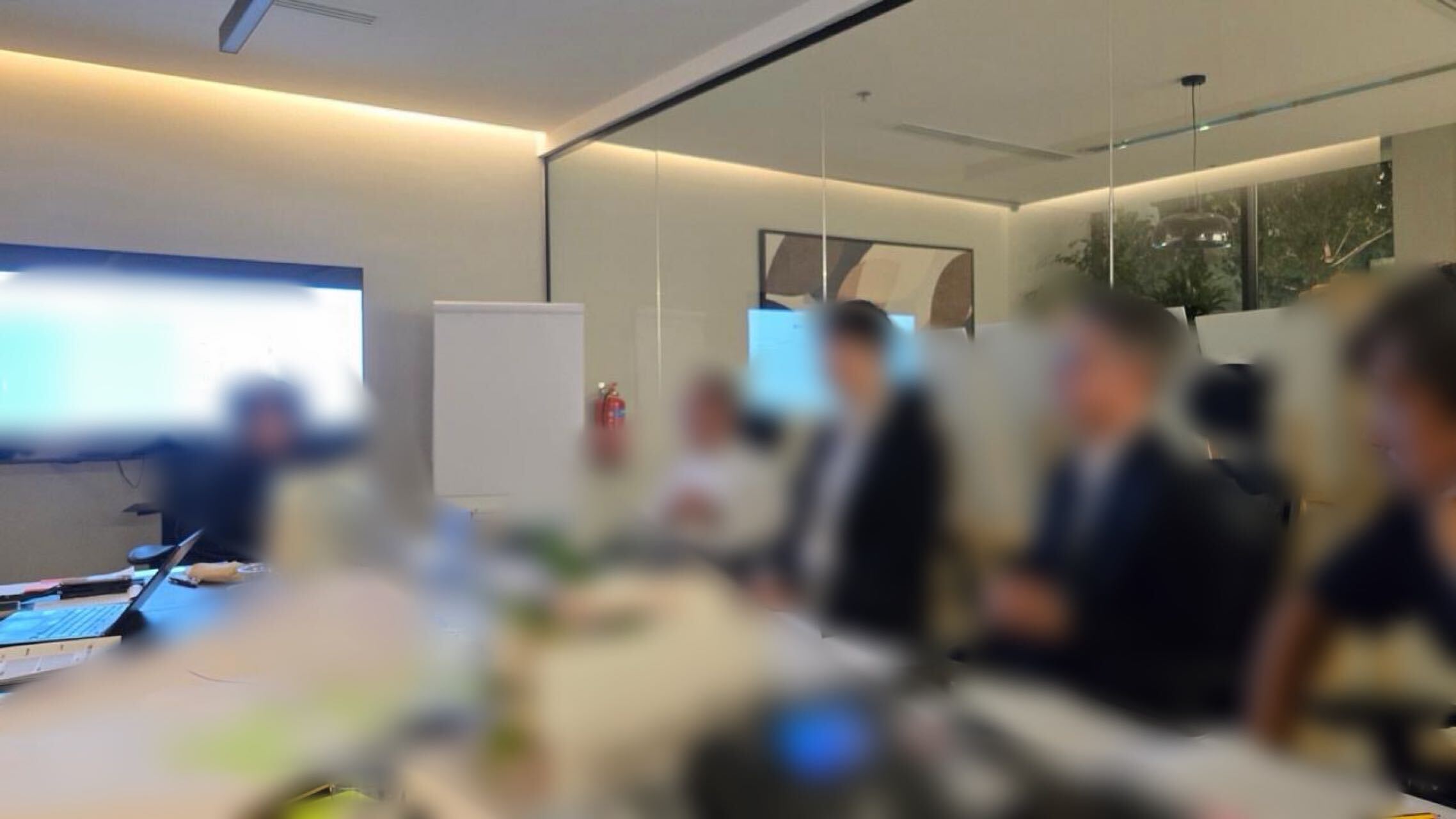 会場のモニターとテーブルを囲んで意見を交わすJapan KAIZEN Sessionの参加者